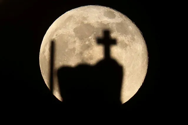 The supermoon is seen behind the crown atop of the statue of Carl the Great in Frankfurt, Germany, April 27, 2021. (Photo by Kai Pfaffenbach/Reuters)