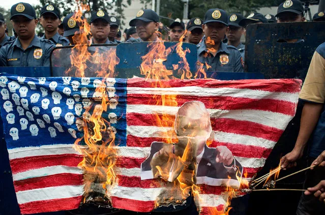 Activists burn a US flag during a protest in front of the US embassy in Manila on February 10, 2017. The protesters denounced the immigration and refugee restrictions recently imposed by US President Donald Trump. (Photo by Noel Celis/AFP Photo)