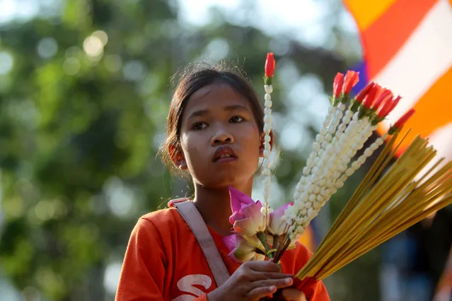A girl takes part at the annual Makha Bucha Day which celebrates Buddha's teachings at the Oudong mountain in Kandal province, Cambodia, February 11, 2017. (Photo by Samrang Pring/Reuters)