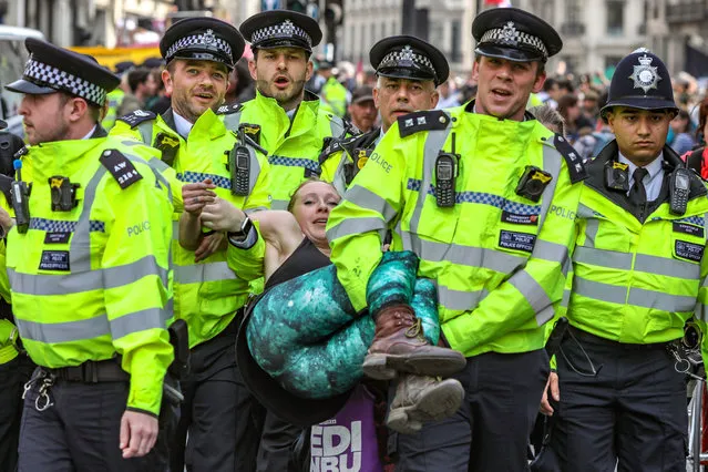 Police arrest protesters as they block traffic on London's Oxford Circus, Thursday, April 18, 2019. The group Extinction Rebellion is calling for a week of civil disobedience against what it says is the failure to tackle the causes of climate change. (Photo by Vudi Xhymshiti/AP Photo)