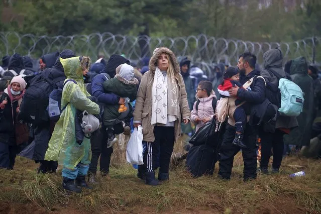 Migrants from the Middle East and elsewhere gather at the Belarus-Poland border near Grodno, Belarus, Monday, November 8, 2021. Poland increased security at its border with Belarus, on the European Union's eastern border, after a large group of migrants in Belarus appeared to be congregating at a crossing point, officials said Monday. The development appeared to signal an escalation of a crisis that has being going on for months in which the autocratic regime of Belarus has encouraged migrants from the Middle East and elsewhere to illegally enter the European Union, at first through Lithuania and Latvia and now primarily through Poland. (Photo by Leonid Shcheglov/BelTA via AP Photo)
