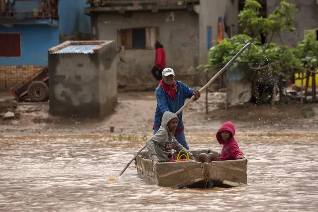 A man steers his boat that is used by residents to move around the street flooded with rain water in Antananarivo, Madagascar, Saturday, January 28, 2023. A tropical storm Cheneso made landfall across north-eastern Madagascar on January 19, brought strong winds to coastal regions, while heavy rain brought significant flooding to northern parts of the country. (Photo by Alexander Joe/AP Photo)