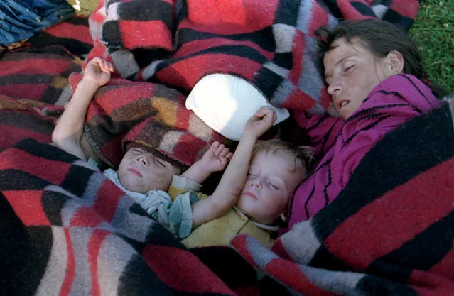A mother and two children from Srebrenica sleep during the dawn hours on the ground outside the U.N. base at Tuzla airport, July 1995. (Photo by Reuters)