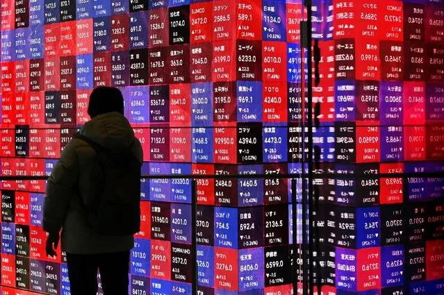 A man looks at an electronic boards displaying stock prices of companies listed on the Tokyo Stock Exchange in Tokyo on March 4, 2024. (Photo by Kazuhiro Nogi/AFP Photo)