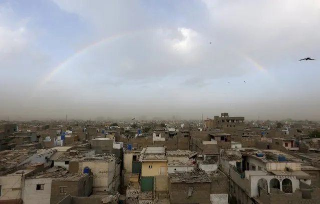 Birds fly as a rainbow arches over houses in a low income neighborhood in Karachi, Pakistan, March 11, 2016. (Photo by Akhtar Soomro/Reuters)