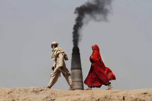 An Afghan couple walk to in front of a brick factory in Surkh Rod district of Jalalabad east of Kabul, Afghanistan, Thursday, June 21, 2012. (Photo by Rahmat Gul/AP Photo)