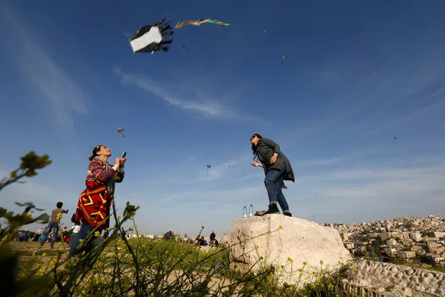 A woman prepares to fly a kite during an event celebrating spring at the Citadel in Amman, Jordan, April 15, 2016. (Photo by Muhammad Hamed/Reuters)