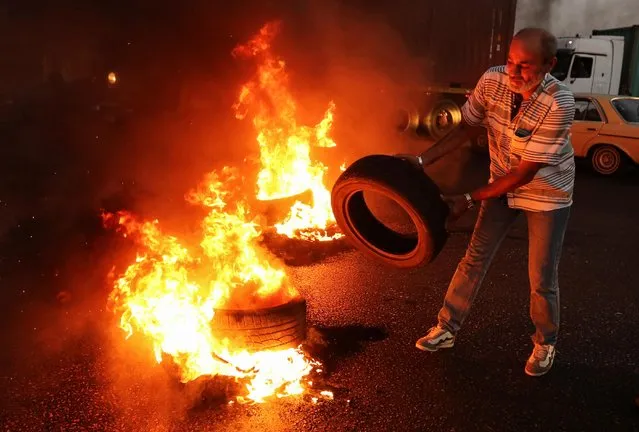 A Lebanese army veteran burns tires during a protest over a state budget that includes a provision taxing their pensions, in Naameh, south of Beirut, Lebanon on June 27, 2019. (Photo by Aziz Taher/Reuters)
