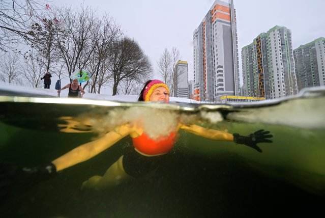 Women bathe in an ice hole in a pond in St. Petersburg, Russia, Tuesday, Jan. 4, 2022. The temperature in St. Petersburg is –7C (19F). (Photo by Dmitri Lovetsky/AP Photo)