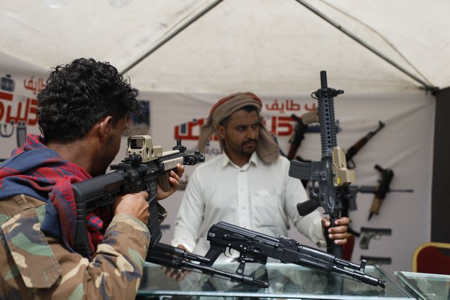 A man checks out an assault rifle at a gun store in a shopping mall in Sanaa, Yemen, Tuesday, February 27, 2024. (Photo by Osamah Abdulrahman/AP Photo)