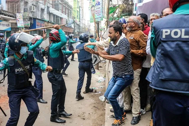 Police personnel charge baton on Bangladesh Nationalist Party (BNP) supporters as they protest during a rally demanding the government to allow ailing ex-premier Khaleda Zia to fly abroad for treatment, in Khulna on November 22, 2021. (Photo by Kazi Santo/AFP Photo)