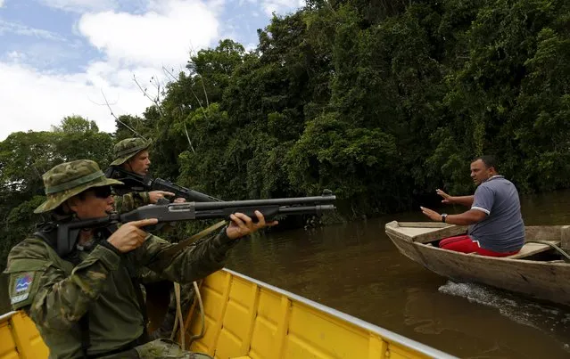 A gold prospector is detained by agents of Brazil’s environmental agency on the Uraricoera River during an operation against illegal gold mining on indigenous land, in the heart of the Amazon rainforest, in Roraima state, Brazil April 15, 2016. (Photo by Bruno Kelly/Reuters)