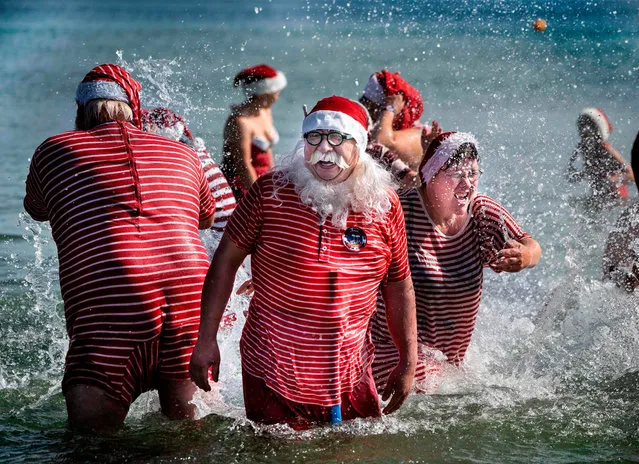 Participants enjoy their annual saltwater bath at Bellevue beach on July 23, 2019, which is held on the sidelines of the in the Santa Claus World Congress from July 22 to 25, at Bakken, north of Copenhagen, Denmark. (Photo by Liselotte Sabroe/Ritzau Scanpix/AFP Photo)