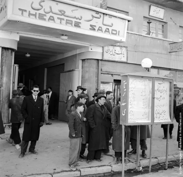 1950:  The exterior of Tehran's Theatre Saadi where a group of people study a billboard