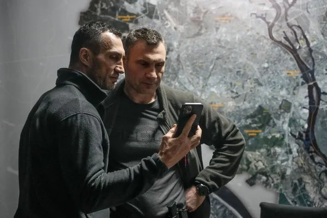 Vitali Klitschko, Kyiv Mayor and former heavyweight champion, right, and his brother Wladimir Klitschko, a Ukrainian former professional boxer look at a smart phone in the City Hall in Kyiv, Ukraine, Sunday, February 27, 2022. (Photo by Efrem Lukatsky/AP Photo)