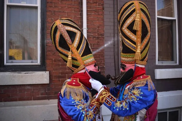 Mexican immigrants adjust their costumes as they prepare to parade through the streets of south Philadelphia, Pennsylvania during the annual Carnaval de Puebla, a traditional Mexican carnival celebration that re-enacts the Battle of Cinco de Mayo, April 27, 2014. Revelers carry mock rifles as they dance and drink in elaborate costumes representing the different armies that fought in the historic battle. (Photo by Charles Mostoller/Reuters)