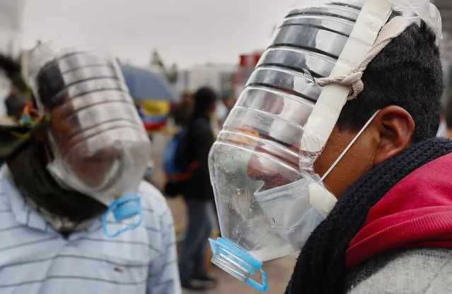 People use homemade gas masks made by Cesar Viteri in Quito, Ecuador, 10 October 2019. Viteri designed his own masks with reused plastic due the need to face tear gases during the clashes in Ecuador's protest. (Photo by Paolo Aguilar/EPA/EFE)