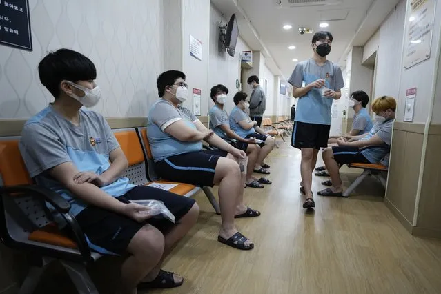 South Korean prospective soldiers wearing face masks wait to receive a medical checkup at the Seoul office of the Military Manpower Administration in Seoul, South Korea, Monday, February 7, 2022. (Photo by Ahn Young-joon/AP Photo)