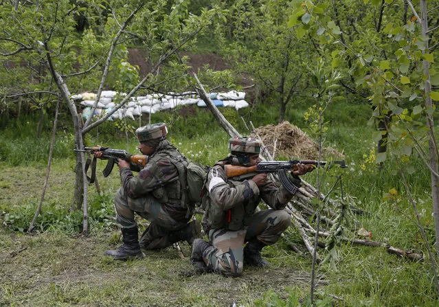 Indian army soldiers take position inside an apple orchard during a search operation in Shopian, about 60 Kilometers south of Srinagar, Indian controlled Kashmir, Thursday, May 4, 2017. Thousands of Indian government forces cordoned off at least two dozen villages in southern Kashmir on Thursday while they hunted for separatist militants believed to be hiding in the area. (Photo by Mukhtar Khan/AP Photo)