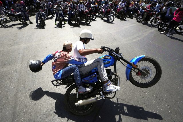 Motorcyclists do tricks as they rally before riding to the closing campaign rally of Venezuelan President Nicolas Maduro who is seeking reelection in Caracas, Venezuela, Thursday, July 25, 2024. The presidential election is set for July 28. (Photo by Matias Delacroix/AP Photo)