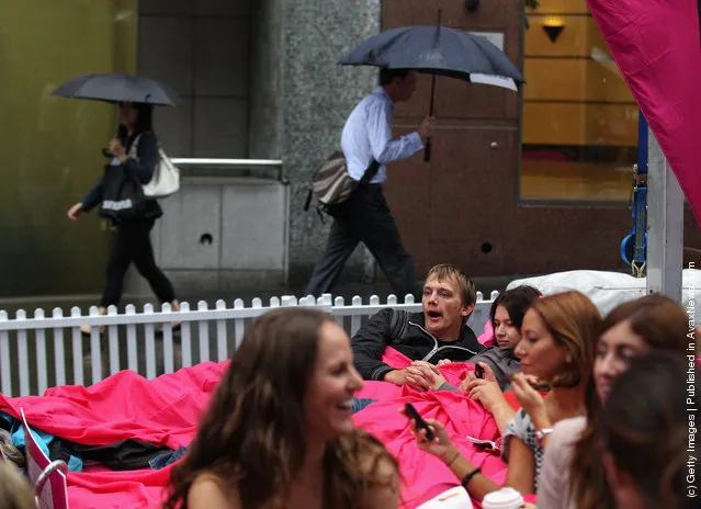 People wait in beds during the The World's Biggest Breakfast in Bed Guinness World Record Attempt at Martin Place in Sydney, Australia
