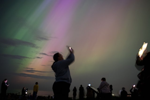 People visit St Mary's lighthouse in Whitley Bay to see the aurora borealis, commonly known as the northern lights, on May 10, 2024 in Whitley Bay, England. The UK met office said a strong solar storm may allow northern parts of the UK the chance to see displays of aurora. (Photo by Ian Forsyth/Getty Images)