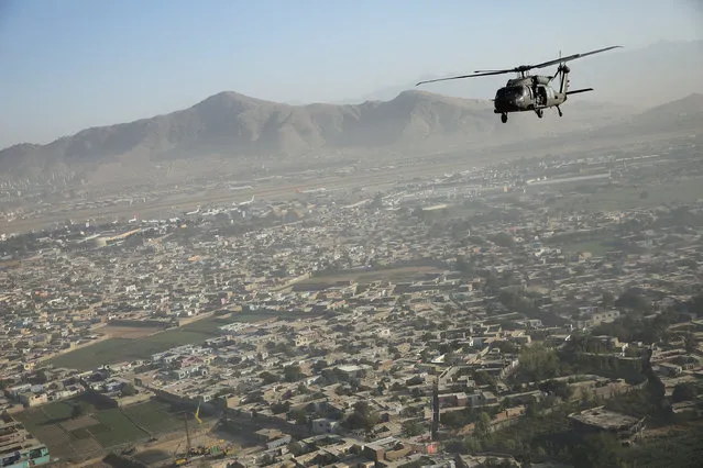 A Blackhawk helicopter flies over Kabul October 3, 2014. (Photo by Dan Kitwood/Reuters)
