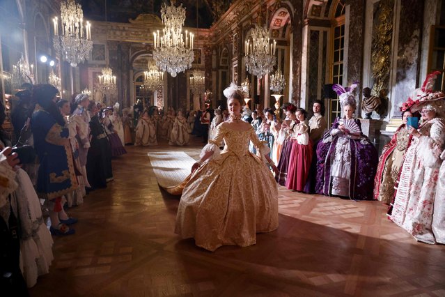 A guest wearing baroque style costume walks through the Hall of Mirrors during the “Fetes Galantes” fancy dress evening at the Chateau de Versailles, outside Paris, on May 22, 2023. The annual fancy dress ball at the Chateau de Versailles aims to re-create the baroque splendour of Louis XIV's dazzling court feasts held to show off the wealth and power of France's longest-reigning monarch at the World Heritage site, one of France's biggest tourist attractions. (Photo by Ludovic Marin/AFP Photo)