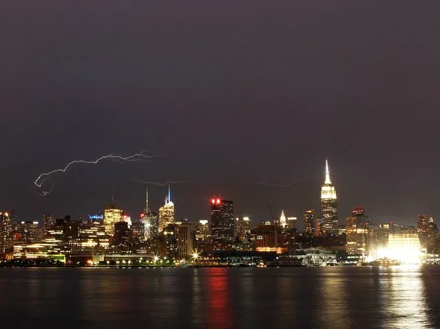 Lightning streaks in the sky over midtown Manhattan in New York on July 2, 2014. (Photo by Gary Hershorn/Corbis Images)