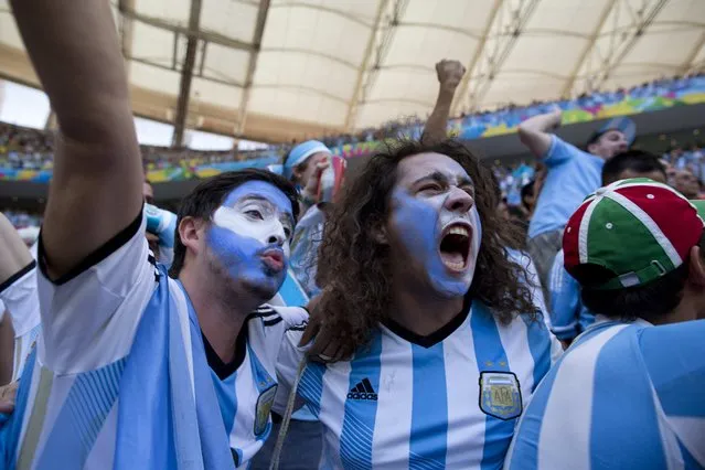 Soccer fans wearing the colors associated with Argentina's national soccer team, celebrate the opening goal scored against Belgium in a World Cup quarterfinals' match at the Estadio Nacional, in Brasilia, Brazil, Saturday, July 5, 2014. (Photo by Rodrigo Abd/AP Photo)
