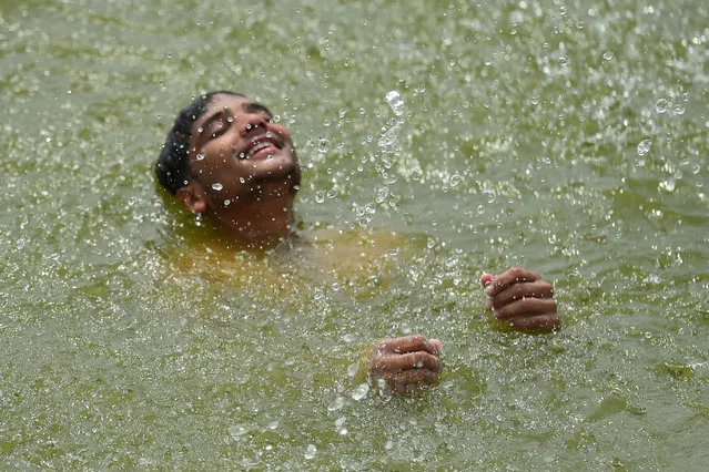 A youth cools off in the Ganges River on a hot summer afternoon in Allahabad on May 27, 2022. (Photo by Sanjay Kanojia/AFP Photo)