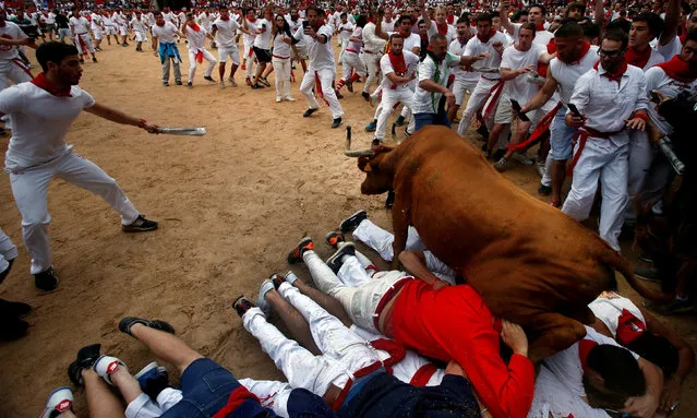 A wild cow leaps over revelers in the bull ring following the fourth running of the bulls at the San Fermin festival in Pamplona, Spain July 10, 2017. (Photo by Joseba Etxaburu/Reuters)
