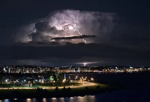 A lightning bolt illuminates clouds during a thunderstorm in Montevideo, Uruguay on April 26, 2022. (Photo by Mariana Suarez/AFP Photo)