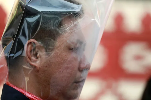 A man wears a plastic bag on his head during an environmental activists' rally to demand rights to clean air, near the Thai Government House in Bangkok, Thailand, as the country struggles to contain worsening air pollution on January 23, 2020. (Photo by Soe Zeya Tun/Reuters)