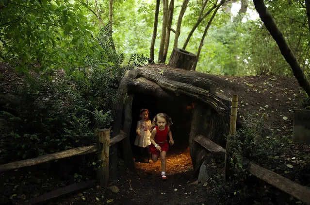 Children play inside an area designed to look like a badger set during a photocall at Kew Gardens on July 20, 2017 in London, England. The Kew Gardens Summer festival includes a newly opened 16 hectare area of the woodland and wilflower meadow. The educational activities focus on pollination, with woodland walks, a treehouse, and boardwalks. (Photo by Dan Kitwood/Getty Images)