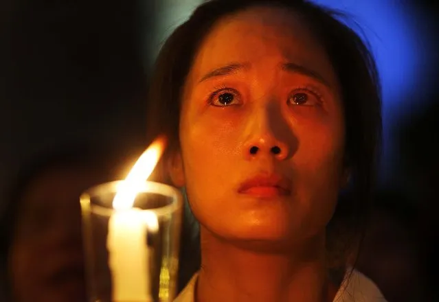A woman, on the brink of tears attends a candlelight vigil to mourn the death of Chinese labor activist Li Wangyang, who was imprisoned for two decades following his arrest in 1989, on June 13, 2012