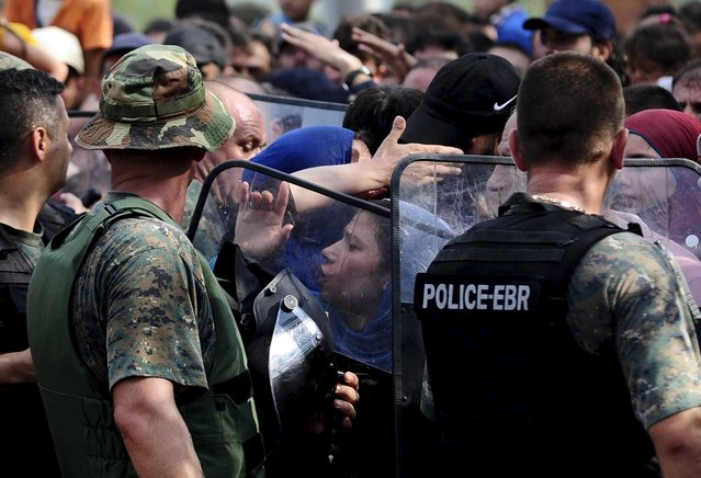 A woman reacts to the police at the border line dividing Macedonia and Greece August 21, 2015. (Photo by Ognen Teofilovski/Reuters)