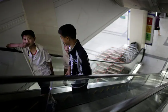 In this Monday, June 19, 2017, photo, boys ride an escalator which takes them to the household items and stationery section of the Potonggang department store in Pyongyang, North Korea. (Photo by Wong Maye-E/AP Photo)