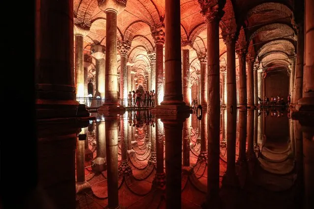 People are reflected in the waters of the Basilica Cistern while visiting the historic site in Istanbul, Turkey, 24 July 2022. (Photo by Sedat Suna/EPA/EFE)