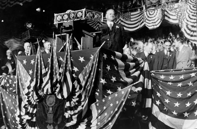 In this October 22, 1928 file photo, Republican presidential candidate Herbert Hoover delivers an address from a U.S. flag-draped podium in Madison Square Garden in New York. (Photo by AP Photo)