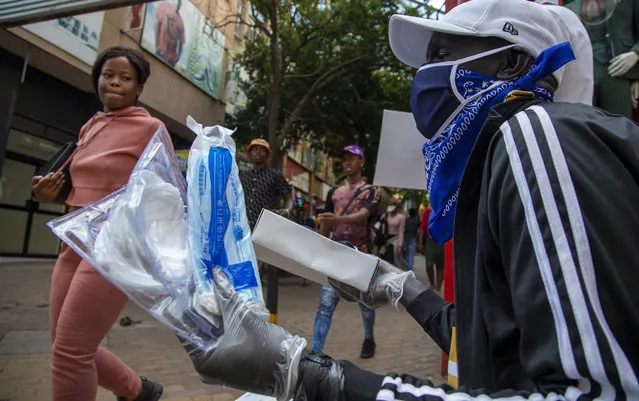 A man wearing a face mask sells masks and gloves in downtown Johannesburg, South Africa, Friday, March 20, 2020. Anxiety rose in Africa's richest nation Friday as South Africa announced coronavirus cases jumped to 202, the most in the sub-Saharan region, while the country's largest airport announced that foreigners would not be allowed to disembark. And state-owned South African Airways suspended all international flights until June. (Photo by Themba Hadebe/AP Photo)