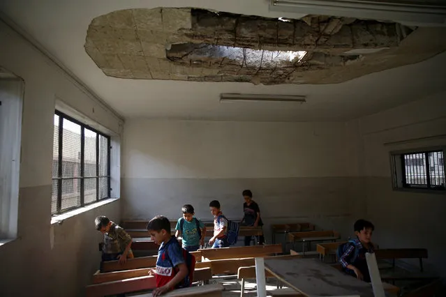 Students walk in a damaged classroom on the first day of school in the rebel-held Douma neighbourhood of Damascus, Syriaon September 16, 2017. (Photo by Bassam Khabieh/Reuters)