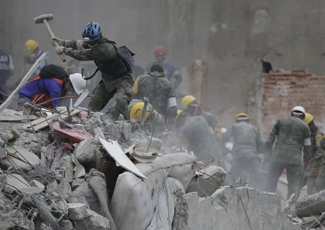 Rescue workers search for survivors at an apartment building located on the street corner of Amsterdam and Laredo, that collapsed during an earthquake in the Condesa neighborhood of Mexico City, Thursday, September 21, 2017. Tuesday's magnitude 7.1 earthquake has stunned central Mexico, killing more than 200 people as buildings collapsed in plumes of dust. (Photo by Natacha Pisarenko/AP Photo)