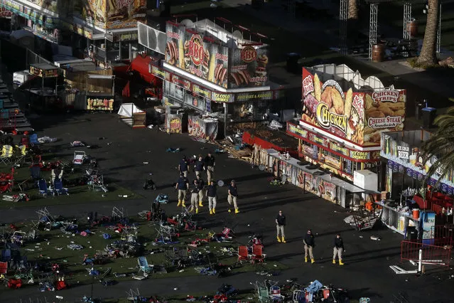 Investigators work at a festival grounds across the street from the Mandalay Bay Resort and Casino on Tuesday, October 3, 2017, in Las Vegas. Authorities said Stephen Craig Paddock broke windows on the casino and began firing with a cache of weapons, killing dozens and injuring hundreds at the music festival on Sunday. (Photo by Marcio Jose Sanchez/AP Photo)