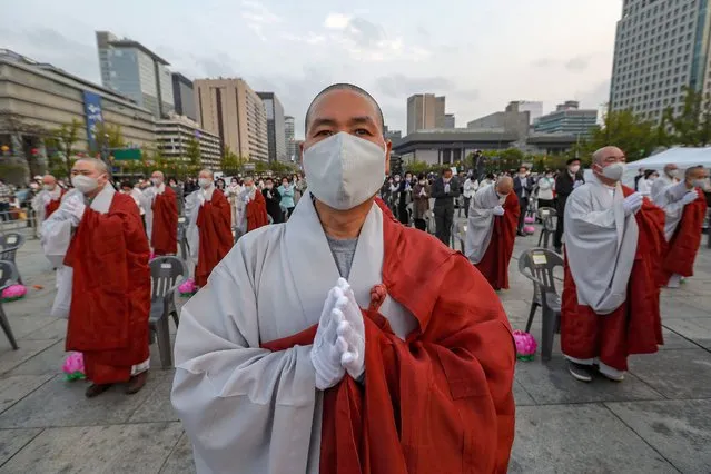 Buddhists monks wearing faces masks to help protect against the spread of the new coronavirus pray to celebrate the Buddha's birthday at the Gwanghwamun Plaza in Seoul, South Korea, Thursday, April 30, 2020. (Photo by Ahn Young-joon/AP Photo)