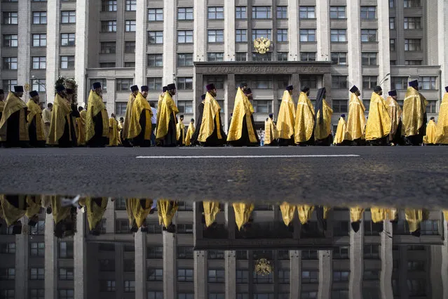 A religious procession marking the 700th anniversary of declaring Moscow the capital of Orthodox Russia pass the State Duma (Russian Parliament), in downtown Moscow, Russia, Sunday, September 6, 2015. (Photo by Pavel Golovkin/AP Photo)