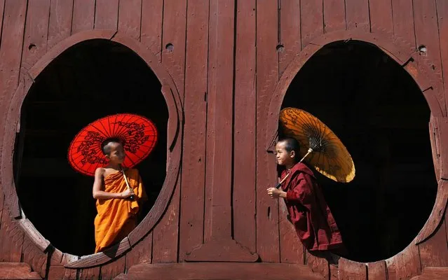 Two young novice monks stare out of the windows of a 200-year-old monastery. The 12-year-olds have been training for the past five years and are unable to see their families while they learn. They are taught to live a simple and meditative life with the hope of one day attaining enlightenment, or nirvana. They live in the Shwe Yaunghwe Kyaung monastery in Nyaungshwe, on the shores on Inle Lake Lake in Myanmar. (Photo by Sabina Akter/Solent News Photo Agency)