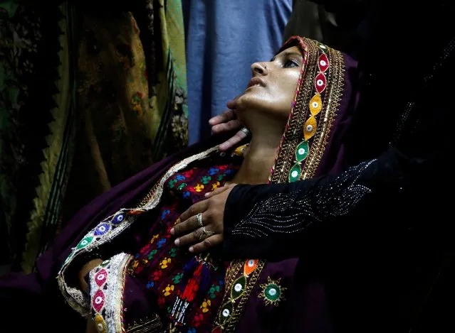 Koonjh, 25, a flood-affected woman and suffering from fever, is taken care by a relative as she waits for medical assistance at Sayed Abdullah Shah Institute of Medical Sciences in Sehwan, Pakistan September 29, 2022. (Photo by Akhtar Soomro/Reuters)