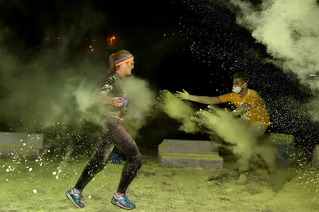 A participant runs through coloured powder as they celebrate in The Color Run Night in Brussels, Belgium, August 20, 2016. (Photo by Eric Vidal/Reuters)