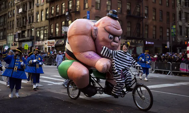 A participant bikes along Sixth Avenue during the Macy's Thanksgiving Day Parade in New York, Thursday, November 23, 2017. (Photo by Andres Kudacki/AP Photo)